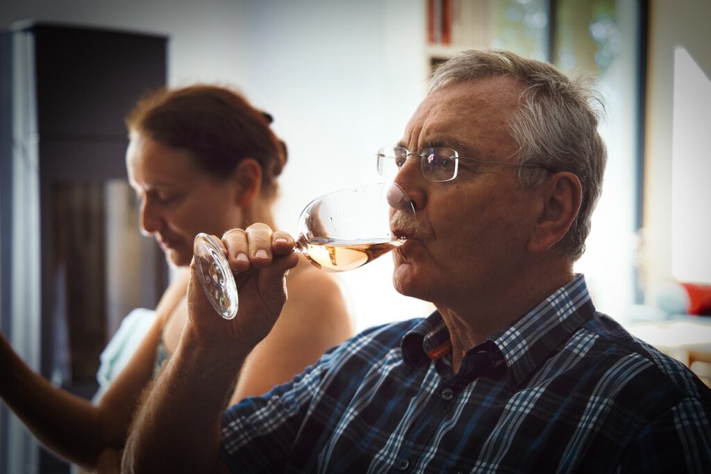 Älterer Mann der Wein trinkt